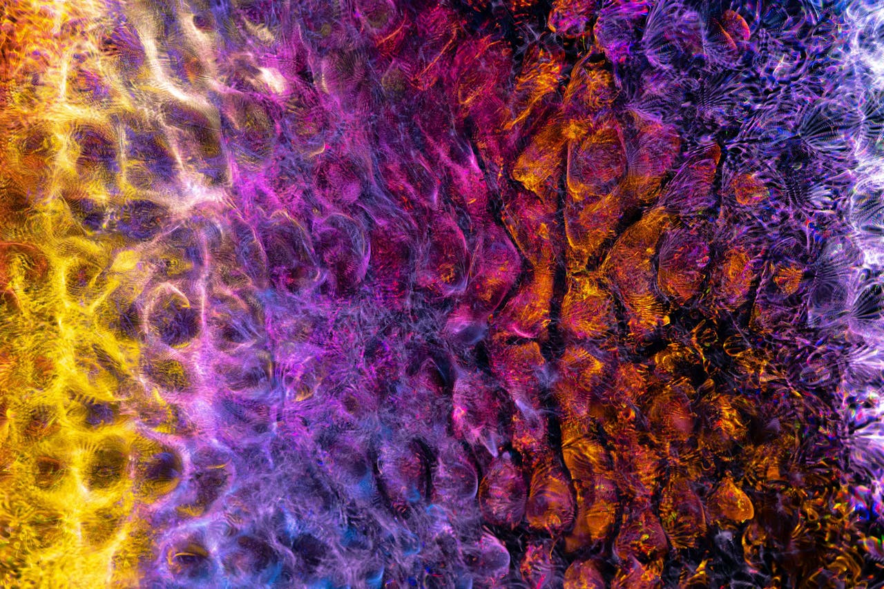 Vibrant psychedelic abstract art with swirling textures in yellow, magenta, purple, and gold tones